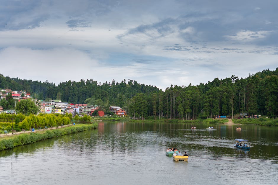 Tranquil landscape of Mirik Lake with boats, surrounded by lush greenery and a serene townscape.