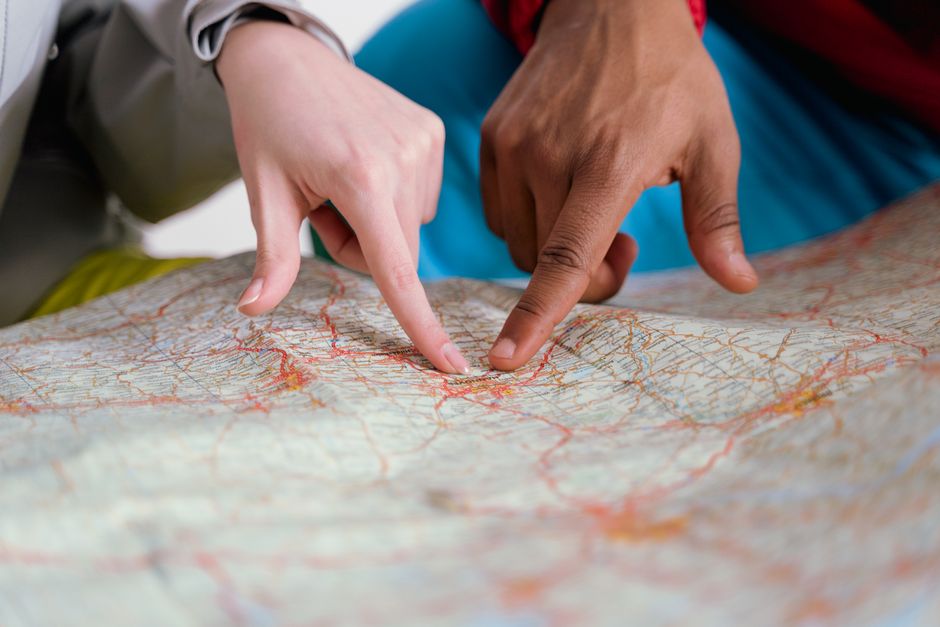 Hands pointing at a paper map while planning a route