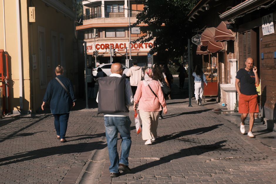 People walking in İzmir's historic street, capturing daily life in Türkiye.